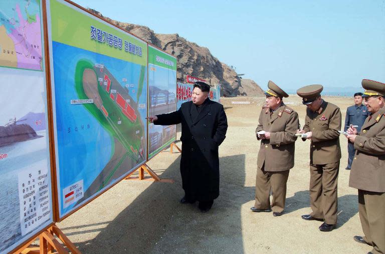 North Korean leader Kim Jong-Un (L) inspects construction site of a fish processing factory in South Hwanghae province, in March 2015