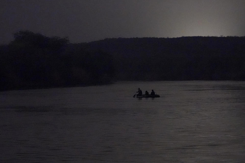 FILE - People cross the U.S.-Mexico border early March 24, 2021, in Roma, Texas. The Rio Grande Valley came alive each night with inflatable rafts carrying families across the meandering river. (AP Photo/Julio Cortez, File)