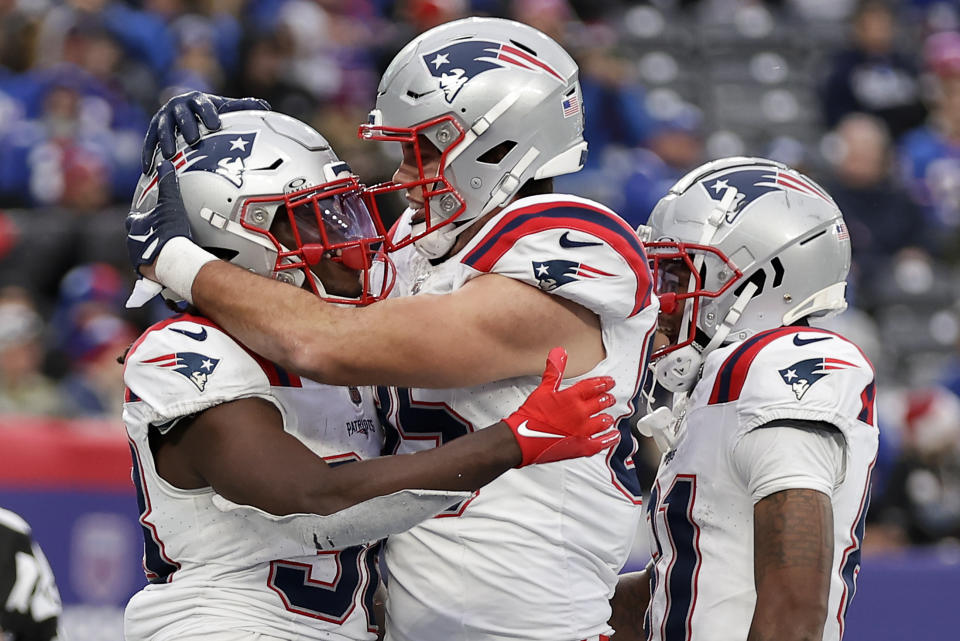 New England Patriots running back Rhamondre Stevenson left, celebrates with tight end Hunter Henry (85) after scoring a touchdown against the New York Giants during the third quarter of an NFL football game, Sunday, Nov. 26, 2023, in East Rutherford, N.J. (AP Photo/Adam Hunger)