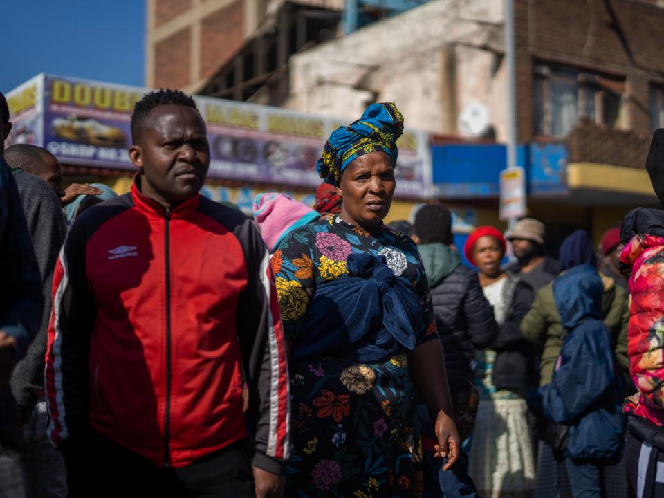 People gather to watch rescue efforts at a multi-story building used by homeless people that caught fire, in downtown Johannesburg, South Africa, (AP)