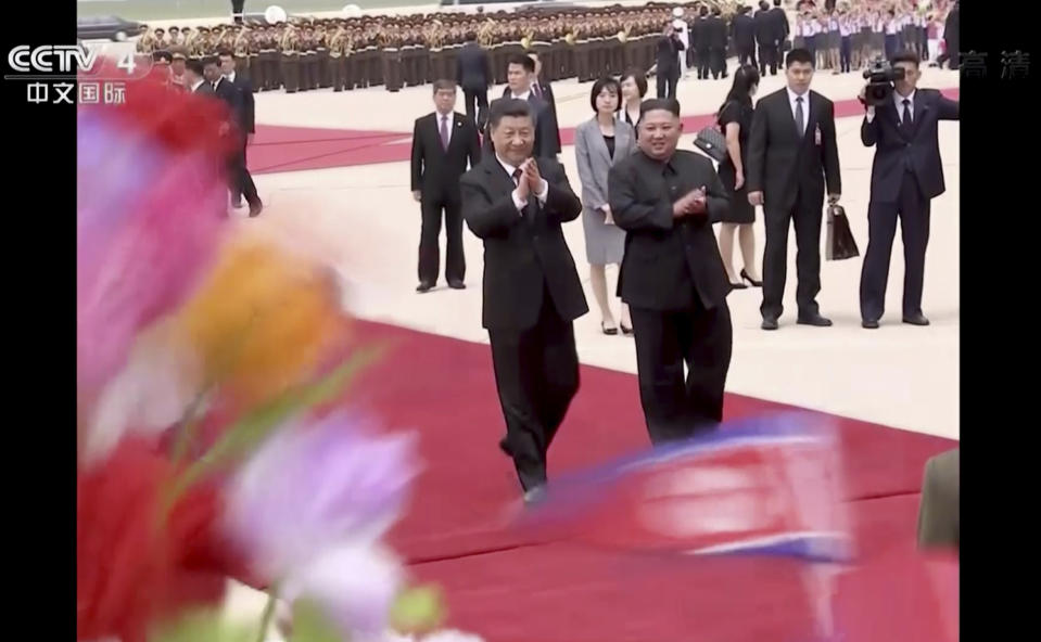 In this image taken from a video footage run by China's CCTV, North Korean leader Kim Jong Un, front right, and Chinese President Xi Jinping, front left, walk together on Xi's arrival at an airport in Pyongyang, North Korea, Thursday, June 20, 2019. The leaders of China and North Korea met in the North's capital on Thursday, their fifth meeting in 15 months, with stalled nuclear negotiations with Washington expected to be on the agenda. (CCTV via AP)