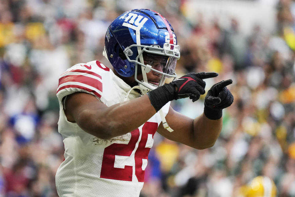 New York Giants running back Saquon Barkley (26) celebrates a touchdown during the second half of an NFL football game against the Green Bay Packers at the Tottenham Hotspur stadium in London, Sunday, Oct. 9, 2022. (AP Photo/Alastair Grant)