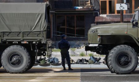 FILE PHOTO - A police officer stands next to trucks during a protest against the new land swap deal, agreed by the heads of the Russian regions of Ingushetia and Chechnya, in Ingushetia's capital Magas, Russia October 8, 2018. REUTERS/Maxim Shemetov