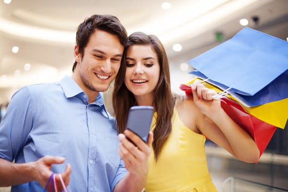 A young couple take a selfie with a smartphone.