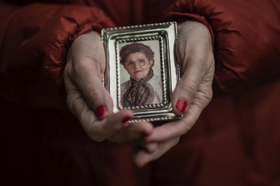 In this Thursday, May 14, 2020 photo, Teresa Navarro shows a picture of her mother Concepcion Rosillos, 97, in Madrid, Spain. Concepcion Rosillos was one of the residents at the Usera Center for the Elderly, who died during the coronavirus outbreak in Spain. More than 19,000 coronavirus deaths in Spain's nursing homes have prompted a re-examination of a system. (AP Photo/Bernat Armangue)