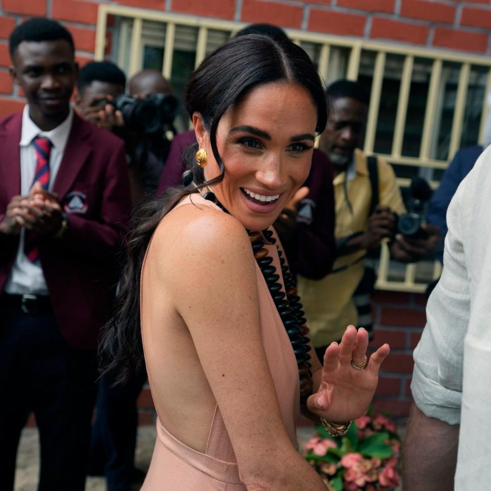 Meghan Markle gestures as she and Prince Harry visit children at the Lights Academy in Abuja, Nigeria, Friday, May 10, 2024. Prince Harry and his wife Meghan have arrived in Nigeria to champion the Invictus Games, which he founded to aid the rehabilitation of wounded and sick servicemembers and veterans