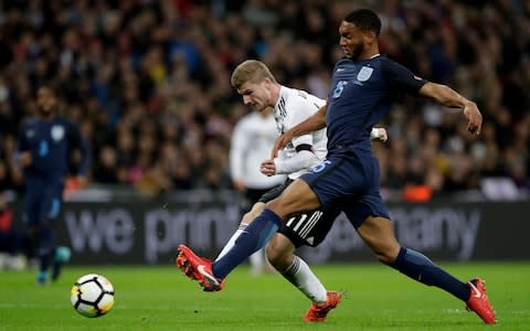 Germany's Timo Werner, left shoots at goal under pressure from England's Joe Gomez - Credit: Matt Dunham/AP