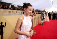 <p>Whether you are going to the gym or out for a fun weekend, Millie Bobby Brown’s adorable double mini buns can be easily re-created with dainty black ribbons and holding hairspray to keep hair slick. (Photo: Getty Images) </p>