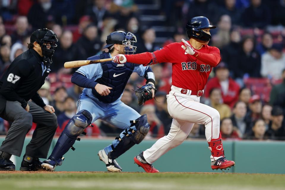 Boston Red Sox's Masataka Yoshida, right, follows through on an RBI-single in front of Toronto Blue Jays' Danny Jansen, center, during the fourth inning of a baseball game, Thursday, May 4, 2023, in Boston. (AP Photo/Michael Dwyer)