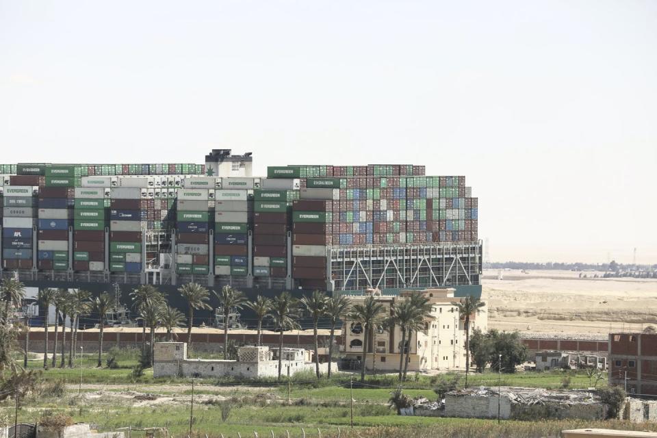 The Ever Given cargo ship loaded with shipping containers appear stuck in the mud along the Suez Canal in March 2021