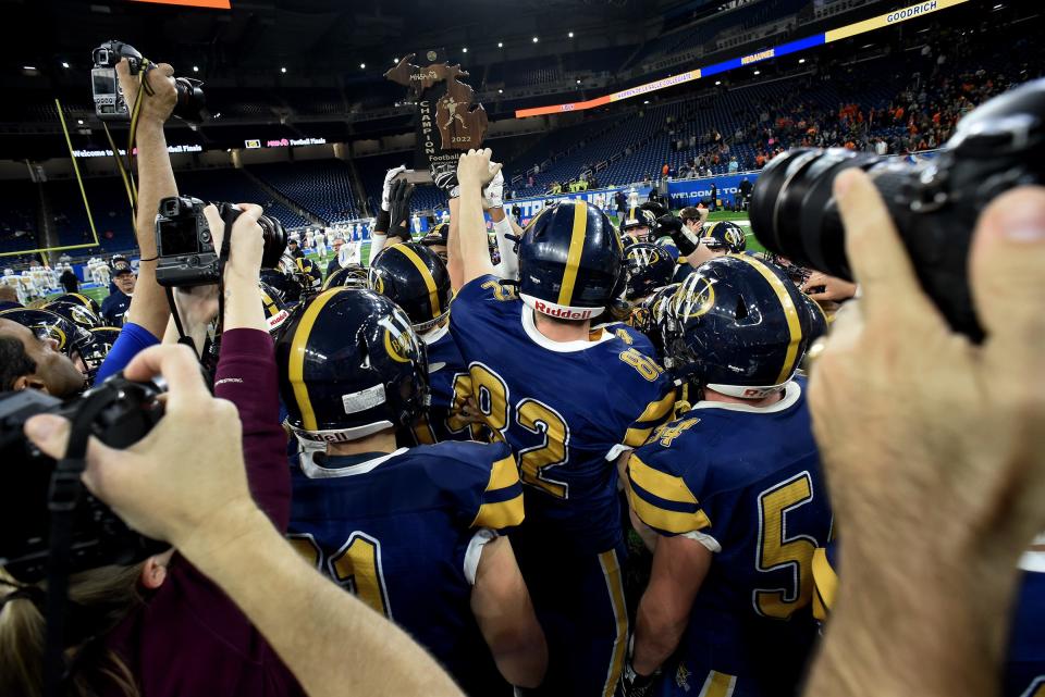 Whiteford's football team raises the championship trophy after defeating Ubly 26-20 in the Division 8 state championships at Ford Field on Friday, November 25, 2022.