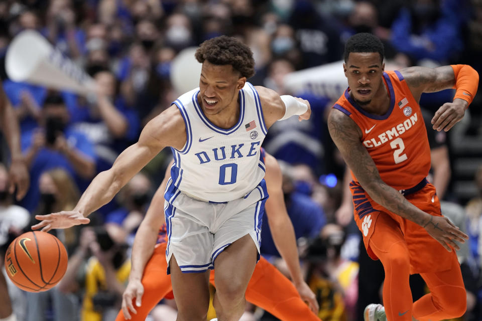 Duke forward Wendell Moore Jr. (0) reaches for the ball while Clemson guard Al-Amir Dawes (2) chases during the first half of an NCAA college basketball game in Durham, N.C., Tuesday, Jan. 25, 2022. (AP Photo/Gerry Broome)