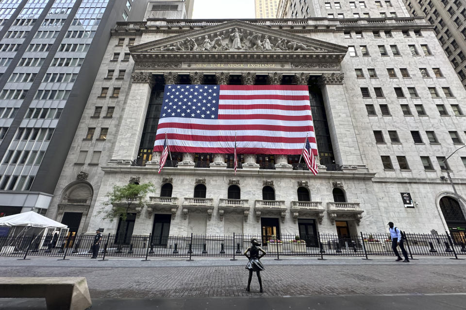 FILE - People pass the New York Stock Exchange on May 28, 2024, in New York. Shares have opened higher in Europe on Thursday, May 30, 2024, after a retreat in Asia. U.S. futures sank and oil prices fell back.(AP Photo/Peter Morgan, File)