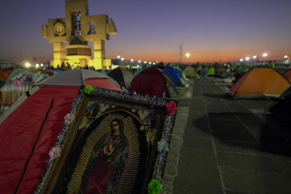 Una imagen de la Virgen de Guadalupe se encuentra en medio de los peregrinos que acampan frente a la Basílica de Guadalupe en la Ciudad de México, la madrugada del lunes 12 de diciembre de 2022. (AP Fhoto/Aurea Del Rosario)