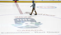 An ice technician walks past center ice after the IIHF junior world hockey championship was cancelled in Red Deer, Alberta on Wednesday, Dec. 29, 2021. The remainder of the world junior hockey championship in Canada has been canceled over fears of a COVID-19 outbreak. The International Ice Hockey Federation made the announcement Wednesday on the recommendation of the organization’s medical officials. (Jeff McIntosh/The Canadian Press via AP)