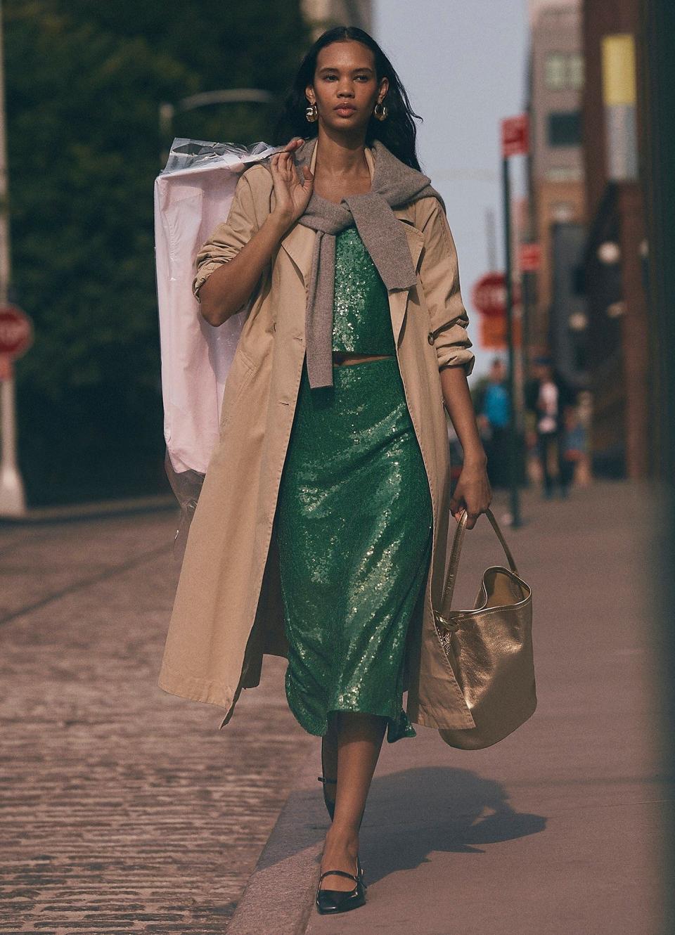 catwalk model in trench coat and jumper tied round neck