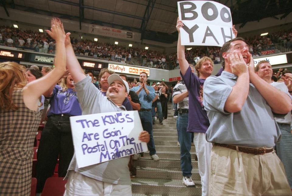 Julian Martinez, holding Kings “goin’ postal” sign, high fives his wife Christine to celebrate the Sacramento Kings’ play against the Utah Jazz in Game 3 of the first-round NBA playoff series at Arco Arena in Sacramento on May 13, 1999.