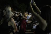 People enjoy during a festivity known as Panigiri, in Aski village about 115 kilometers (72 miles) north of Athens, Greece, early Sunday, Aug. 14, 2022. The Dormition of the Virgin Mary (or Mother of God as the Greeks usually refer to her) is celebrated on Aug. 15. The religious event is coupled with midsummer festivities, known as Panigiria, that often last more than a day with music, culinary feasts and, in many cases, flea markets. (AP Photo/Thanassis Stavrakis)