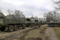 A convoy of military trucks parked in a street in Mykolaivka, Donetsk region, the territory controlled by pro-Russian militants, eastern Ukraine, Sunday, Feb. 27, 2022. Fighting also raged in two eastern territories controlled by pro-Russia separatists. (AP Photo)