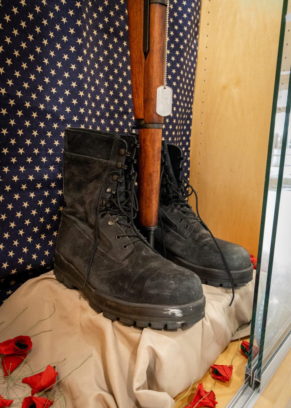 A pair of boots and a rifle with a helmet placed on the butt of a rifle make up a Battlefield Cross on display for Memorial Day at the Shasta County Administration Center.