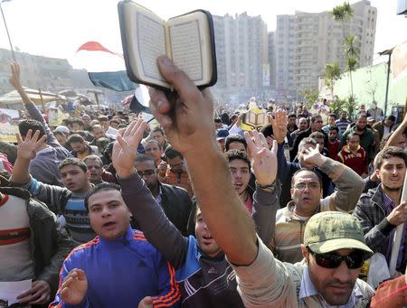 People shout slogans against the military and interior ministry as others hold up copies of the Koran during an Islamist protest in the Cairo suburb of Matariya November 28, 2014. REUTERS/Mohamed Abd El Ghany