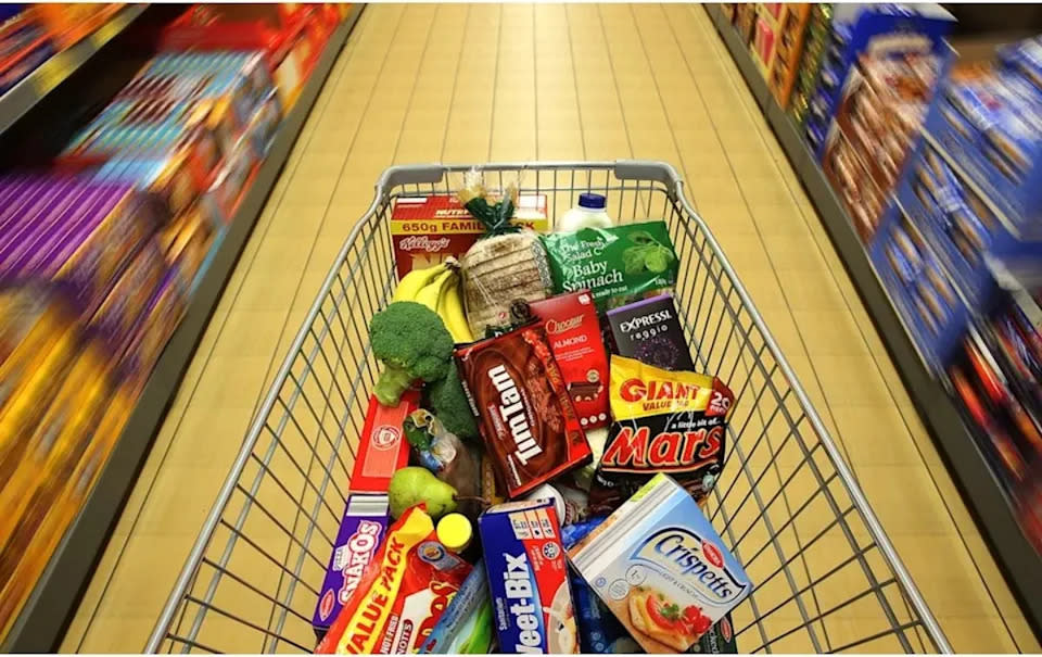 Aldi shopping trolley full of groceries in supermarket aisle