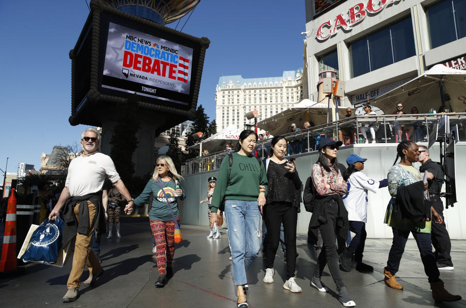 People walk near the Paris Las Vegas hotel casino, site of a Democratic presidential debate, Wednesday, Feb. 19, 2020, in Las Vegas. Nevada's first-in-the West presidential caucus puts the spotlight Saturday on a state that has swung increasingly blue over the last two decades. (AP Photo/John Locher)