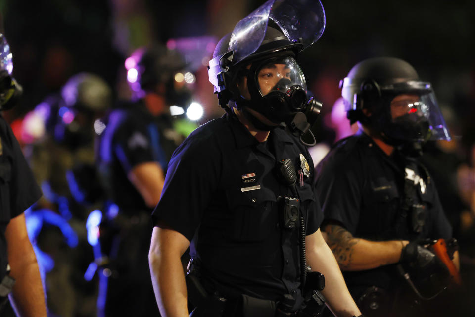 Denver Police officers wear riot gear before tear gas and rubber bullets were used to disperse a protest outside the State Capitol over the death of George Floyd, a handcuffed black man in police custody in Minneapolis, late Thursday, May 28, 2020, in Denver. Protesters walked from the Capitol down the 16th Street pedestrian mall during the protest. (AP Photo/David Zalubowski)