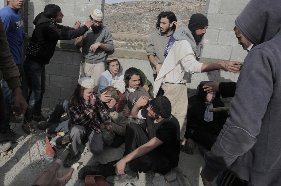 Palestinians from the village of Qusra (L) detain, at a construction site, a group of Israeli settlers in the Israeli occupied West Bank, on January 7, 2014 (JAAFAR ASHTIYEH/AFP/Getty Images)