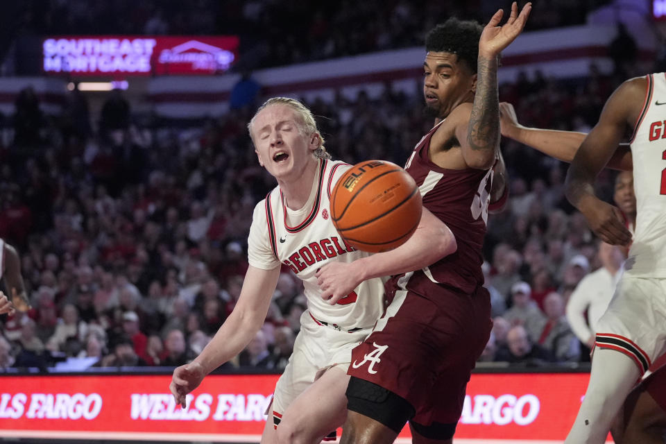Georgia guard Blue Cain (0) loses control of the ball as he tries to drive past Alabama guard Aaron Estrada (55) in the second half of an NCAA college basketball game Wednesday, Jan. 31, 2024, in Athens, Ga. (AP Photo/John Bazemore)