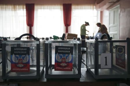 Members of a local electoral commission take part in the preparations for the upcoming election, with stickers displaying symbols of the self-proclaimed Donetsk People's Republic seen on ballot boxes, at a polling station in Donetsk, eastern Ukraine, October 31, 2014. REUTERS/Maxim Zmeyev