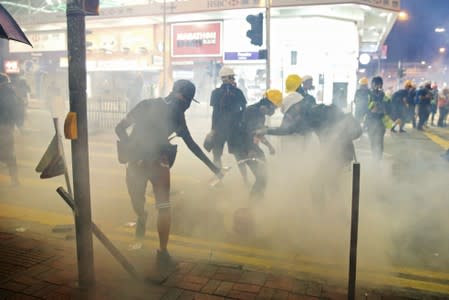 Demonstrators try to extinguish tear gas with water during an anti-extradition bill protest in Hong Kong