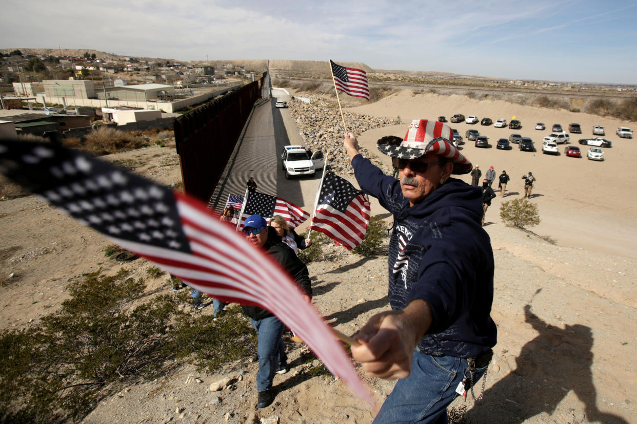 U.S demonstrators hold U.S flags at the open border to make a human wall in support of the construction of the new border wall between U.S and Mexico in Ciudad Juarez, Mexico February 9, 2019. REUTERS/Jose Luis Gonzalez     TPX IMAGES OF THE DAY