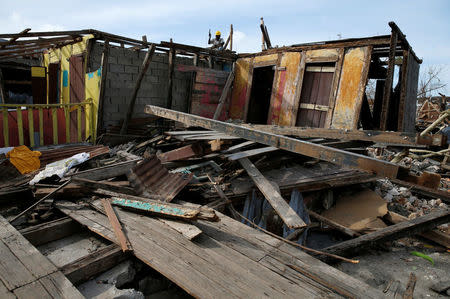 A man repairs the roof of a damaged house after Hurricane Matthew passes in Jeremie, Haiti, October 9, 2016. REUTERS/Carlos Garcia Rawlins