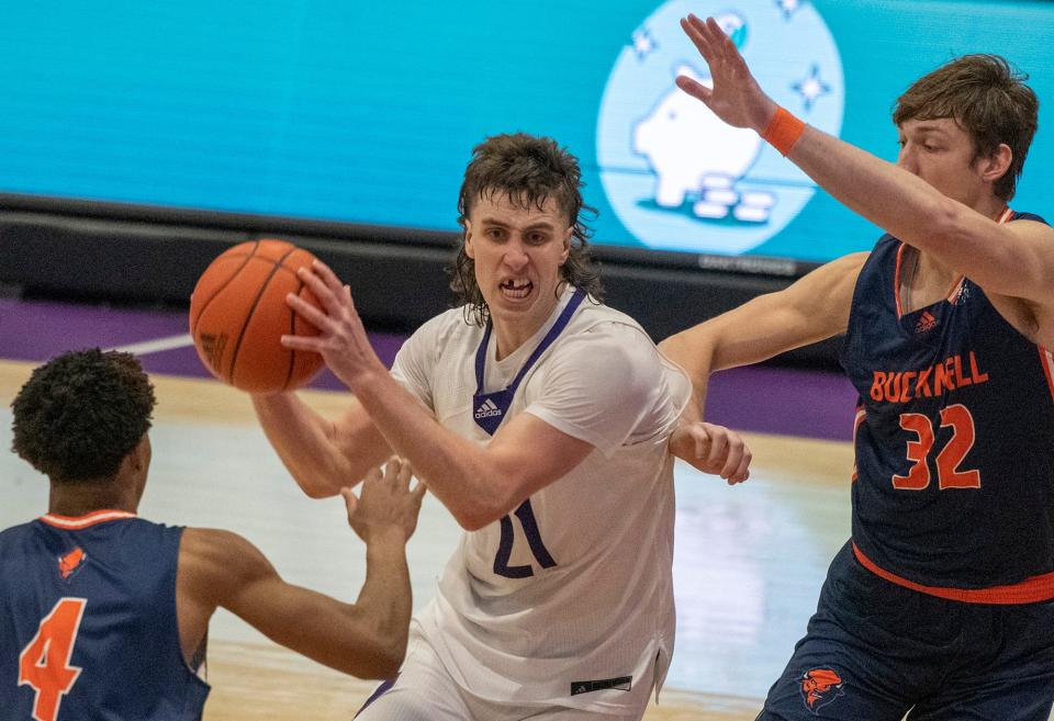 Holy Cross’s Nolan Dorsey looks for an opening between Bucknell’s Josh Fulton and Jake van der Heijden Friday at the Hart Center.