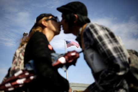 A flag of the U.S. flutters behind a Mexican couple kissing before crossing into El Paso, Texas, U.S. on the Paso del Norte international bridge, in this picture taken from Ciudad Juarez