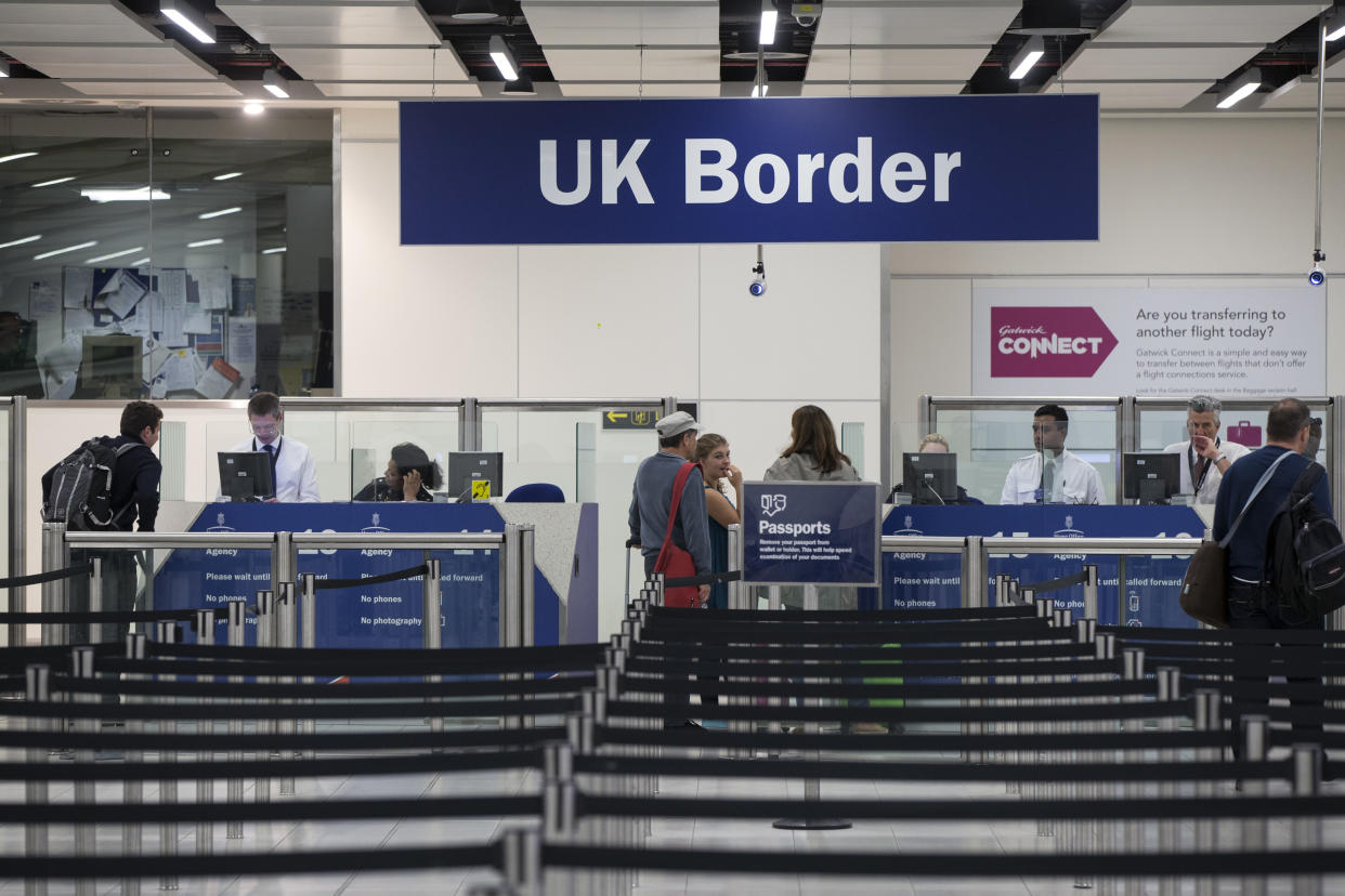 LONDON, ENGLAND - MAY 28:  Border Force check the passports of passengers arriving at Gatwick Airport on May 28, 2014 in London, England. Border Force is the law enforcement command within the Home Office responsible for the security of the UK border by enforcing immigration and customs controls on people and goods entering the UK. Border Force officers work at 140 sea and airports across the UK and overseas.  (Photo by Oli Scarff/Getty Images)