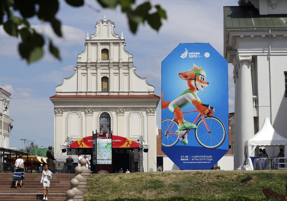 In this photo taken on Wednesday, June 19, 2019, people pass by advertisement billboard in Minsk, Belarus. Shrunken in size and struggling for attention, the European Games open Friday in Belarus which is one of the continent’s most isolated countries. There was a lavish inaugural event in Azerbaijan four years ago with the opening ceremony alone costing $95 million and starring Lady Gaga. But it wasn’t enough to attract many big-name athletes to Minsk for this year’s event. (AP Photo/Sergei Grits)