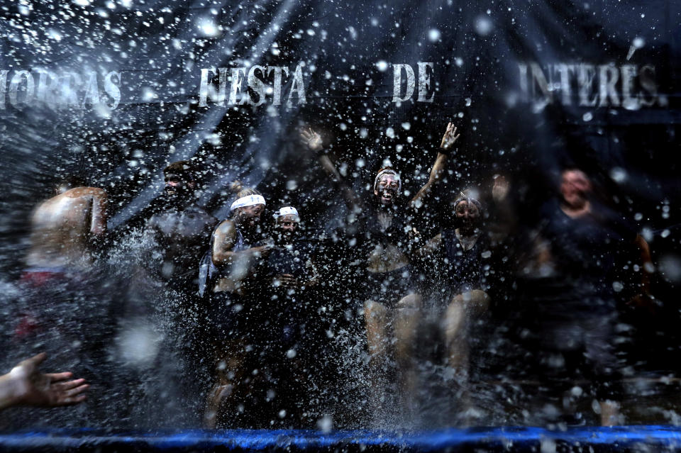 In this photo taken on Friday, Sept. 6, 2019, people painted with black grease celebrate during the traditional festivities of the Cascamorras festival in Baza, Spain. During the Cascamorras Festival, and according to an ancient tradition, participants throw black paint over each other for several hours every September 6 in the small town of Baza, in the southern province of Granada. The "Cascamorras" represents a thief who attempted to steal a religious image from a local church. People try to stop him, chasing him and throwing black paint as they run through the streets. (AP Photo/Manu Fernandez)