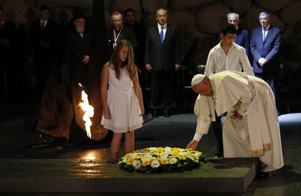 Pope Francis adjusts a wreath after it was laid by two young students during a ceremony at the Yad Vashem Holocaust memorial in Jerusalem