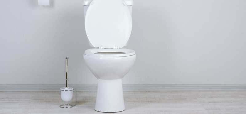 A white toilet in a white bathroom.