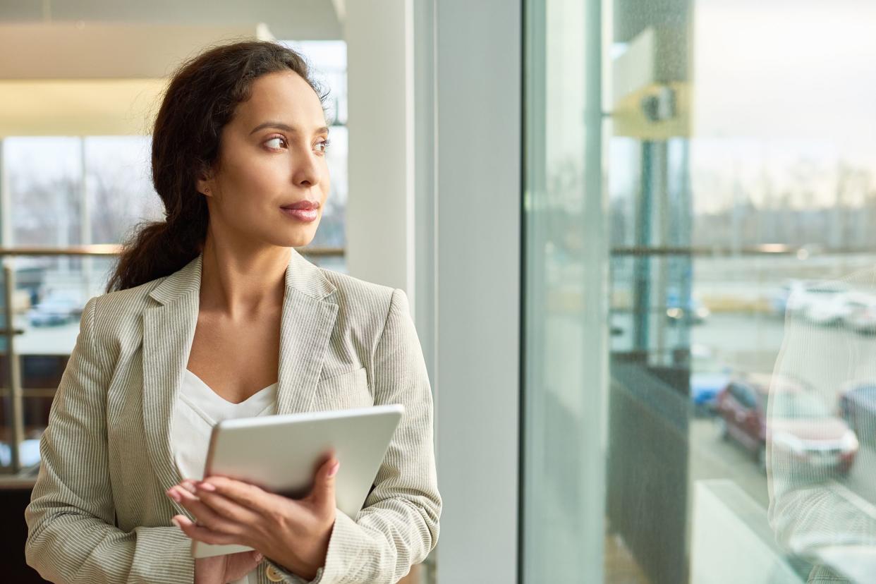 mixed-race businesswoman looking out window