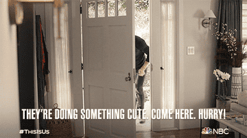 A man walking into his home while pushing his twins in a stroller