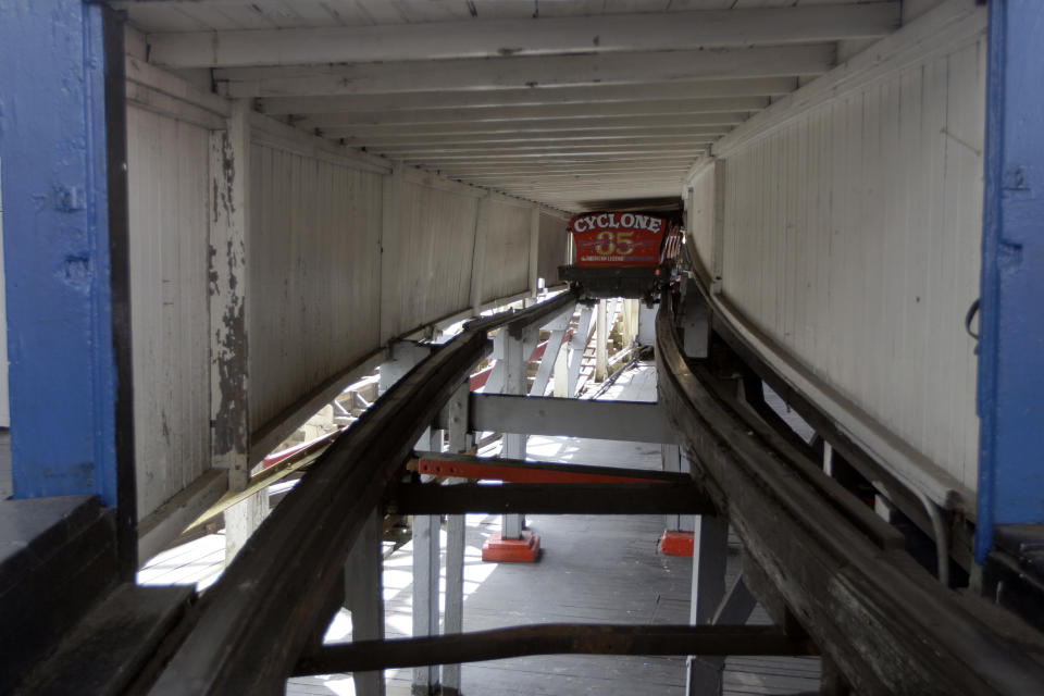 In a Tuesday, June 26, 2012 taken on Coney Island in New York, a car is seen under the tracks of the Cyclone roller coaster.  The New York City landmark and international amusement icon will be feted Saturday, June 30 with a birthday party in its honor.   (AP Photo/Mary Altaffer)