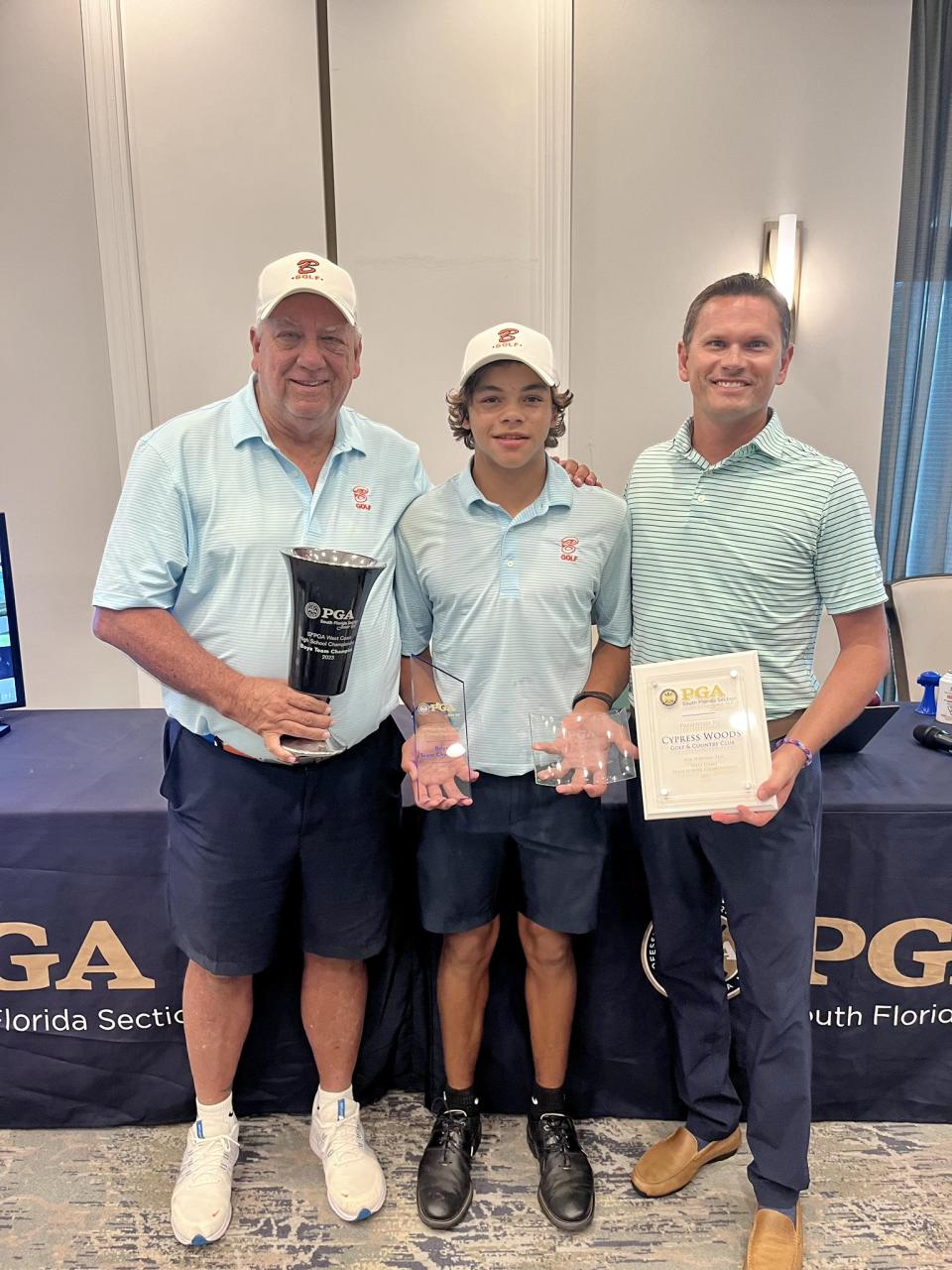 Alongside Benjamin coach Toby Harbeck (left), 14 year-old Charlie Woods (middle) shows off his trophy haul after shooting a 102 to be the individual champ of the SFPGA's West Coast High School tournament at Cypress Woods Golf and Country Club in Naples on Sept. 30, 2023.