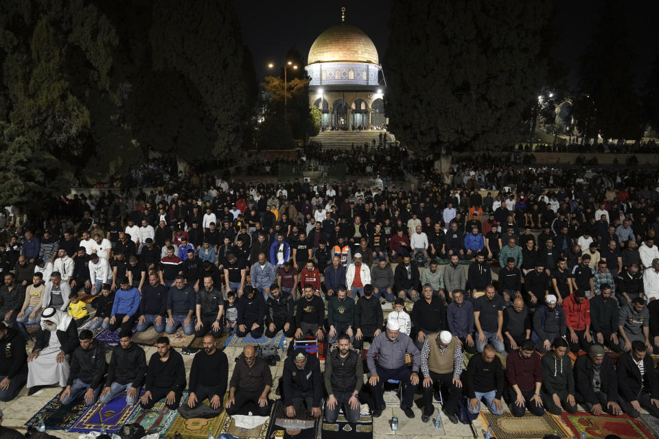 Palestinian worshippers perform "tarawih," an extra lengthy prayer held during the Muslim holy month of Ramadan, next to the Dome of Rock at the Al-Aqsa Mosque compound in the Old City of Jerusalem, Saturday, April 8, 2023. Israel's defense minister on Saturday extended a closure barring entrance to Israel for Palestinians from the occupied West Bank and Gaza Strip for the duration of the Jewish holiday of Passover, while police beefed up forces in Jerusalem on the eve of sensitive religious celebrations. (AP Photo/Mahmoud Illean)