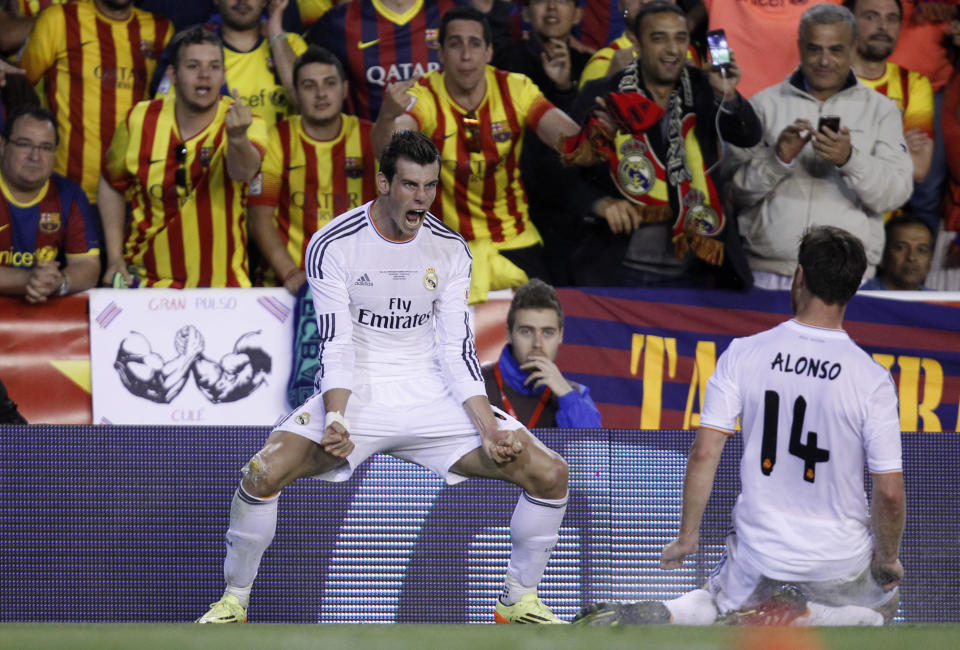 Real's Gareth Bale, left celebrates scoring his team's 2nd goal during the final of the Copa del Rey between FC Barcelona and Real Madrid at the Mestalla stadium in Valencia, Spain, Wednesday, April 16, 2014. (AP Photo/Alberto Saiz)