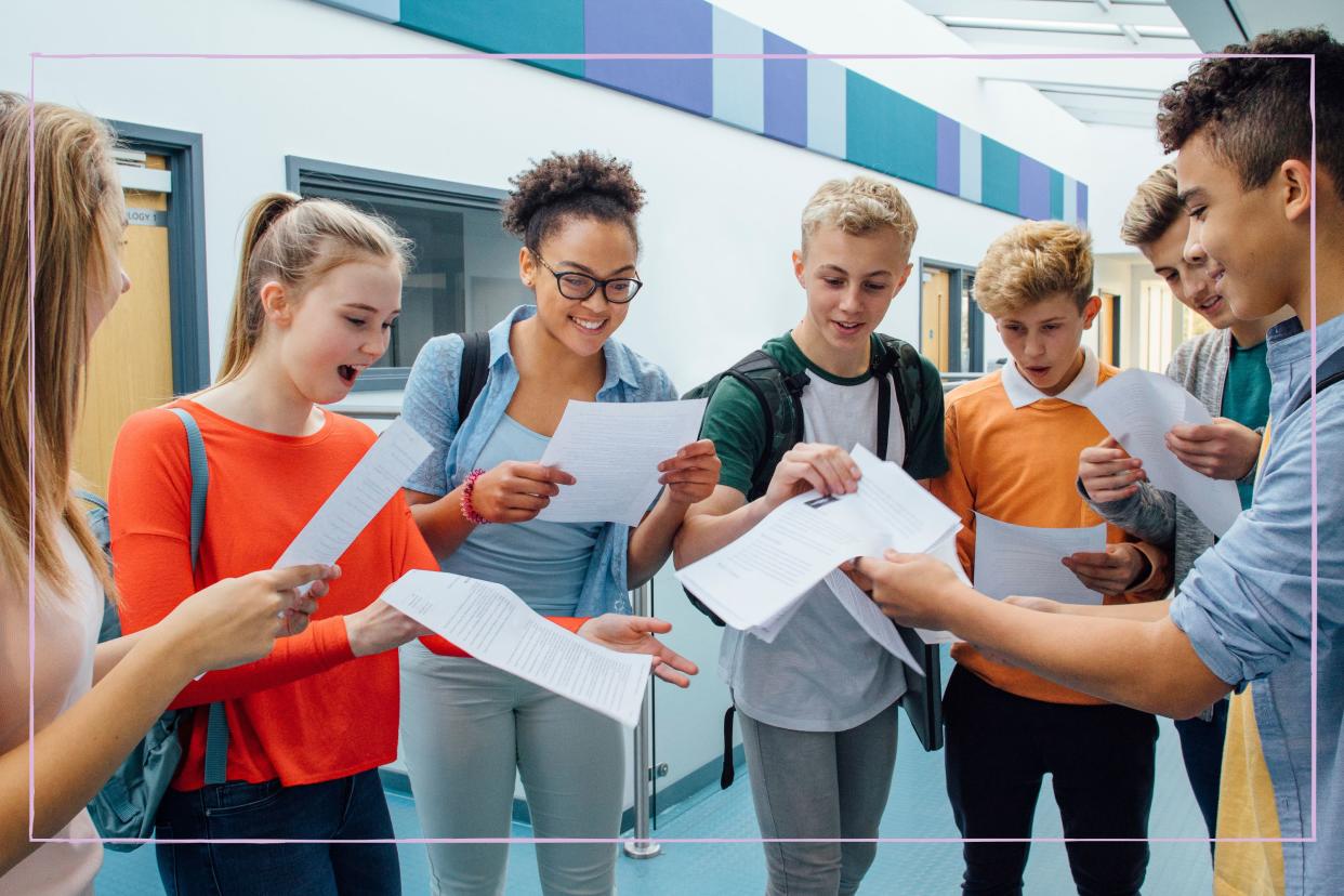  A group of students looking at pieces of paper on a level results day 