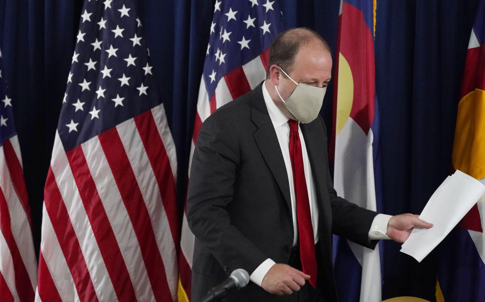 Colorado Governor Jared Polis heads out after discussing the increase in the state's new coronavirus cases over the past three weeks during a news conference Tuesday, Sept. 22, 2020, in Denver. (AP Photo/David Zalubowski)