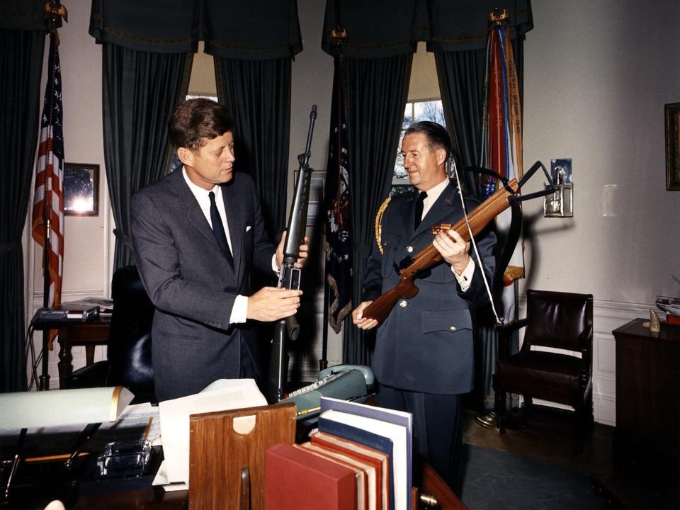 President John F. Kennedy examines an early Colt AR-15 in the White House in 1963.